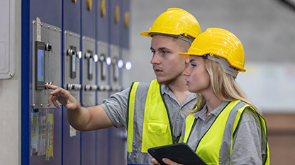 Experts conferring at industrial control panel