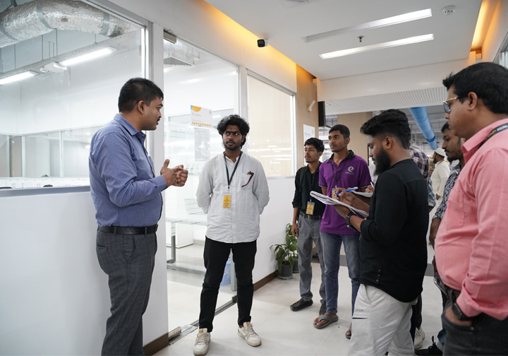 An Intertek colleague addresses a small group of university students. 