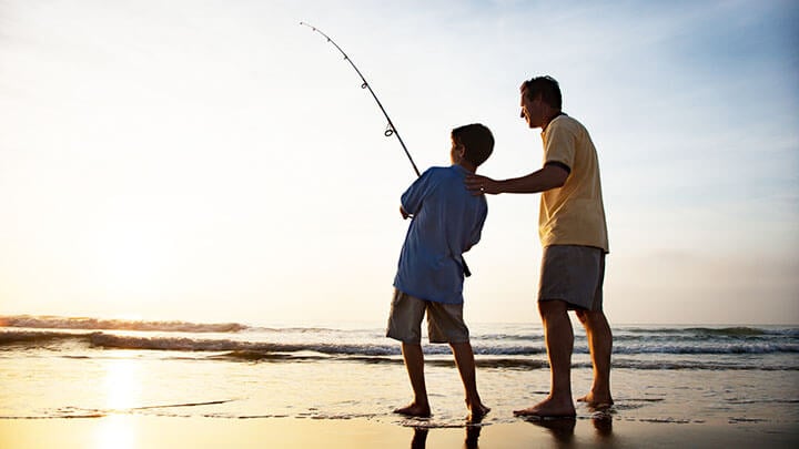 un uomo e un ragazzo che pescano in riva al mare