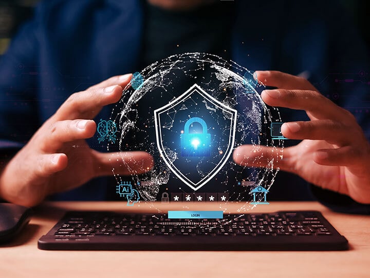 cybersecurity concept with businessman holding a digital globe with a shield and padlock icon, hovering over a keyboard and mouse