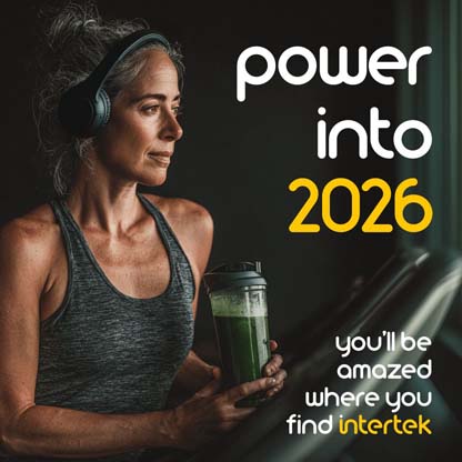A woman leaning against a running machine while holding a healthy drink and wearing headphones