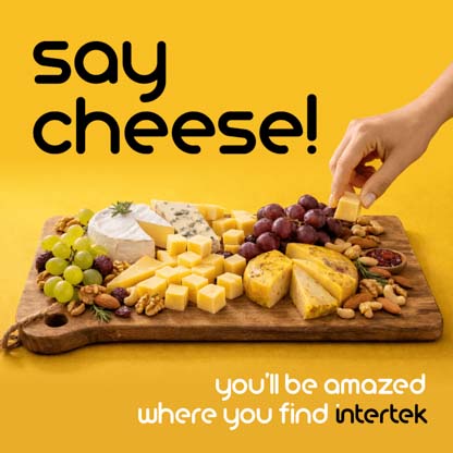A wooden serving board filled with cheese, fruit and nuts